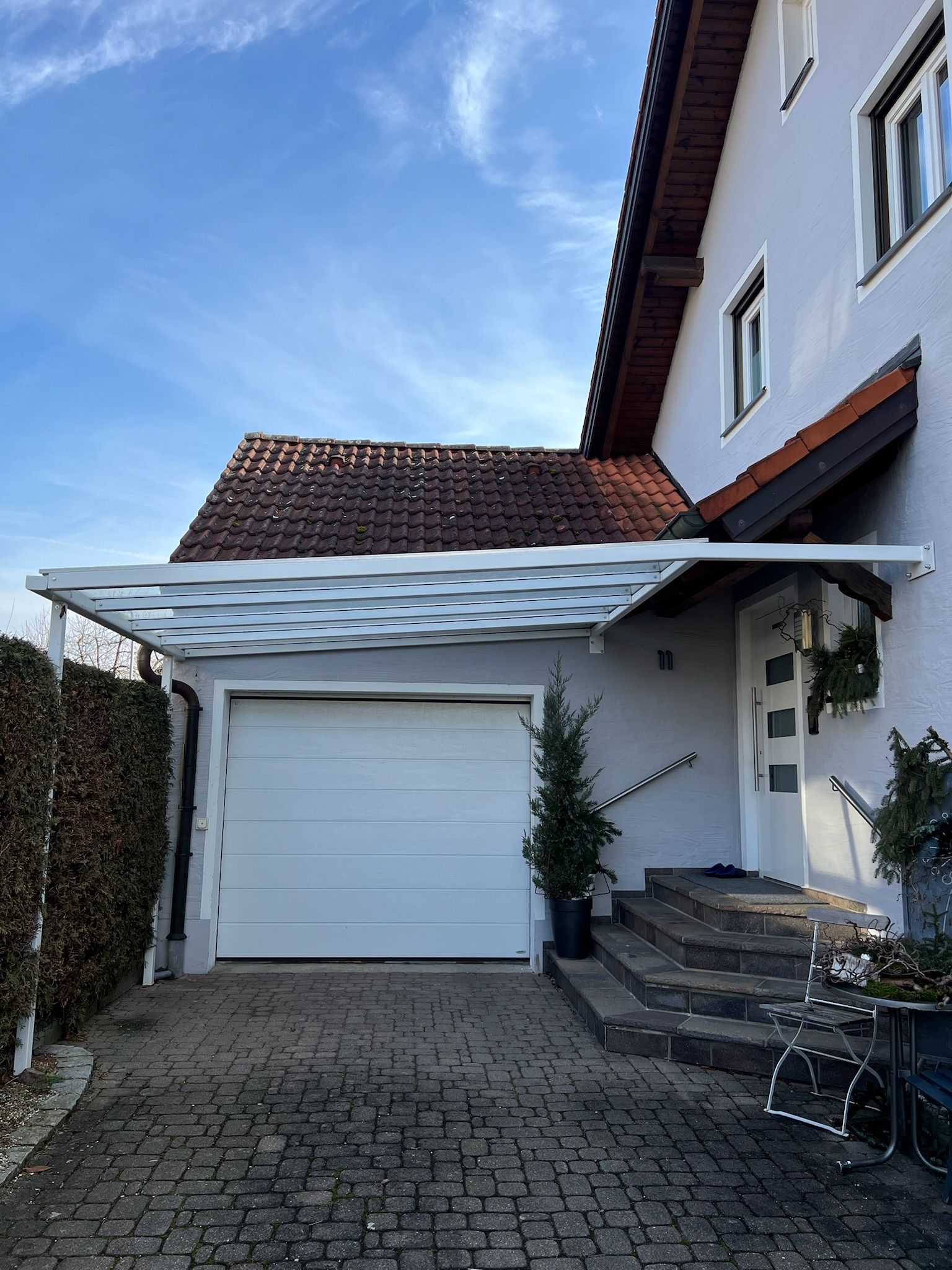 Beschichtete Überdachung vor Garage und Eingang